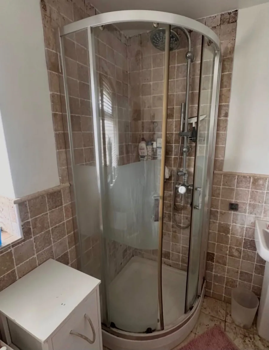 Tired quadrant shower enclosure with an older shower valve before the work