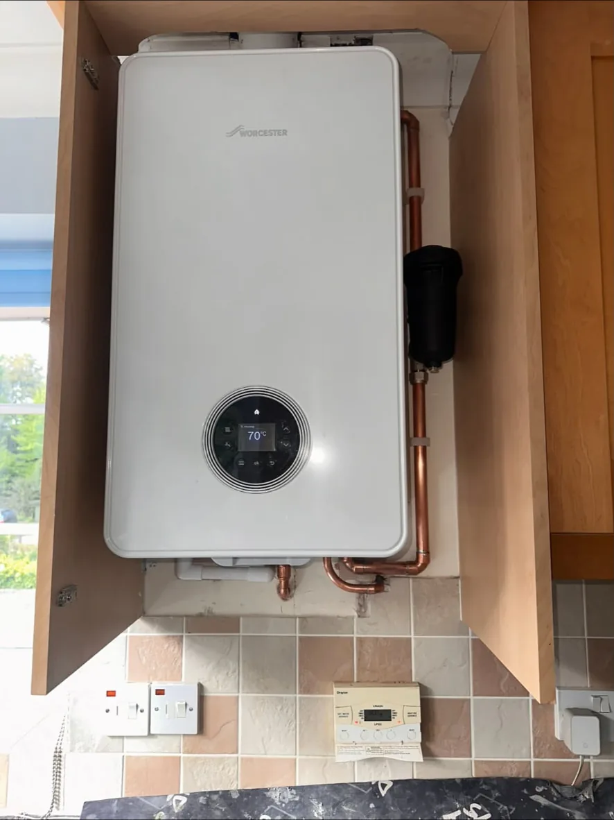 New Worcester Bosch wall-hung gas boiler fitted in the same cupboard with copper pipework and a filter